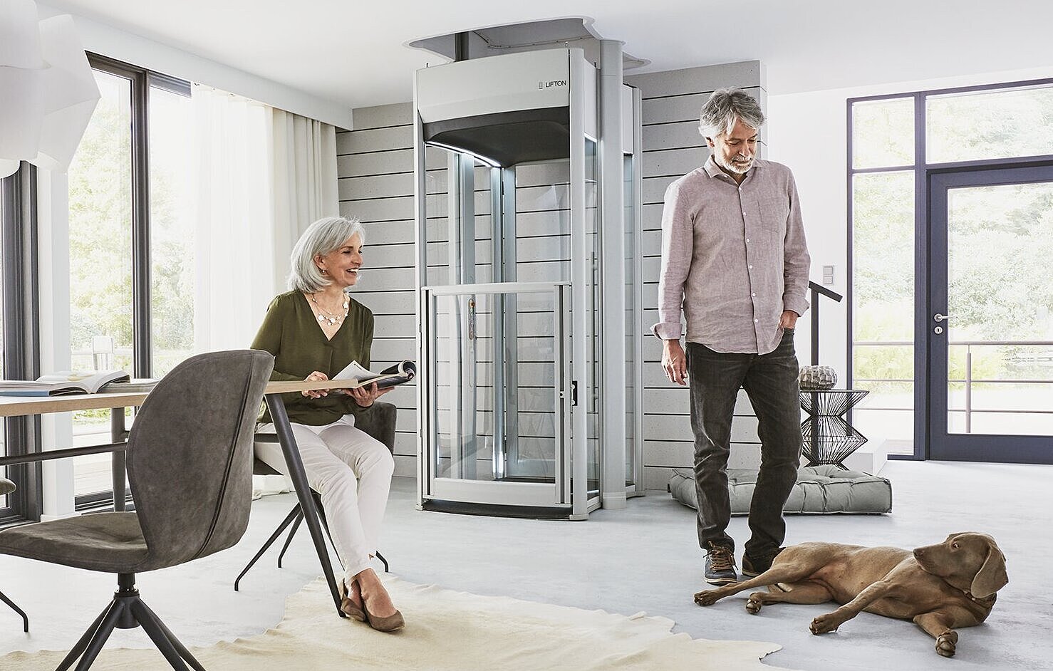 Älteres Ehepaar steht vor ihrem Lift im Wohnzimmer